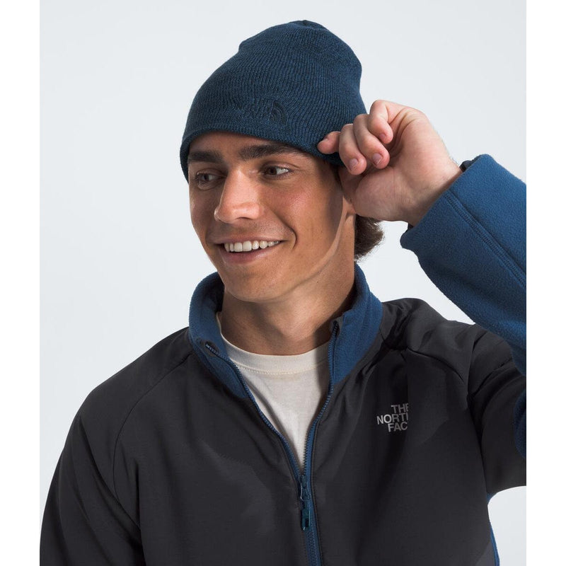 Load image into Gallery viewer, Person wearing a navy beanie and black jacket with The North Face logo on a white background
