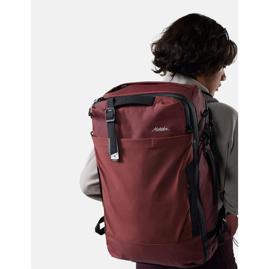 Person wearing a red backpack with a visible brand logo on a white background