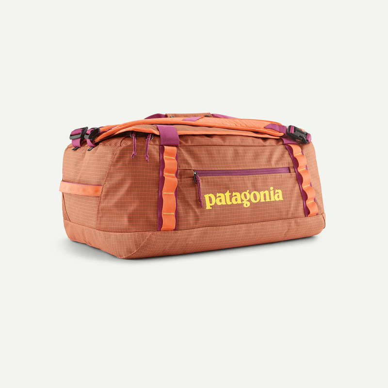 Load image into Gallery viewer, Orange duffel bag with Patagonia logo on a light beige background
