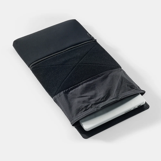 Black laptop sleeve with a white laptop inside on a light gray background