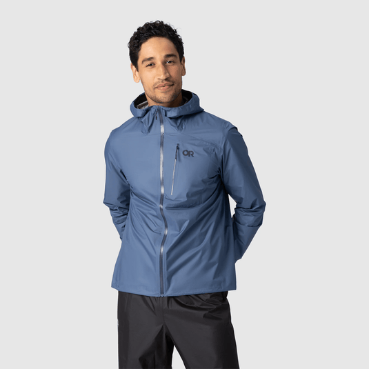 Man wearing a blue jacket with a brand logo on a light gray background