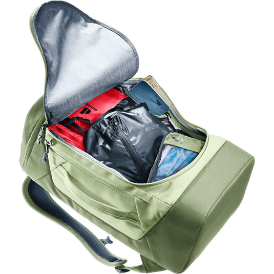 Green backpack with open compartment showing organized items on a white background