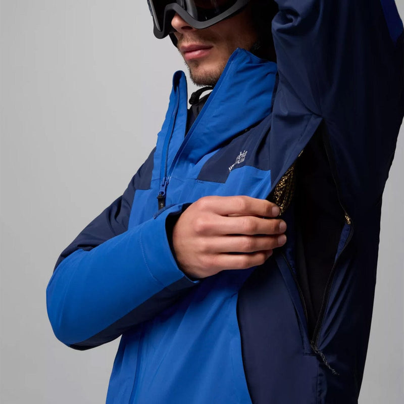 Load image into Gallery viewer, Person wearing a blue and black jacket with a brand logo on a gray background
