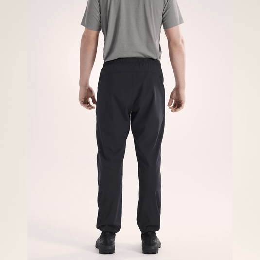 Person wearing black pants and a gray shirt on a plain background