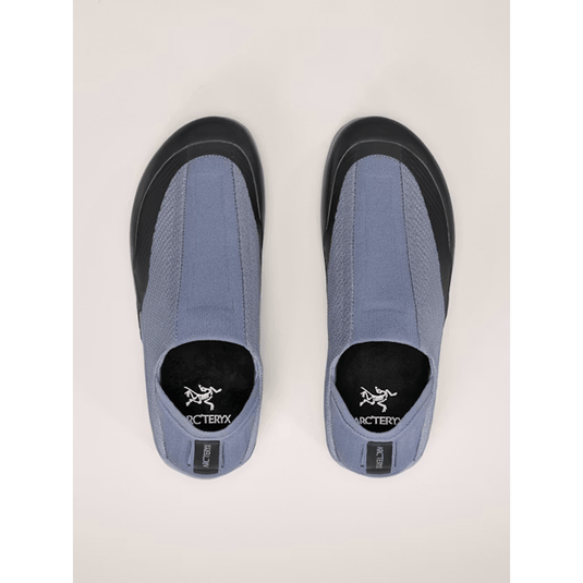 Pair of blue shoes with black soles on a light beige background