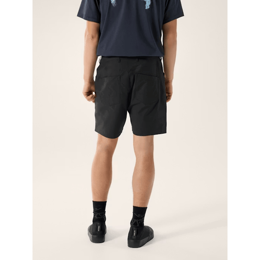 Person wearing black shorts and black shoes on a white background