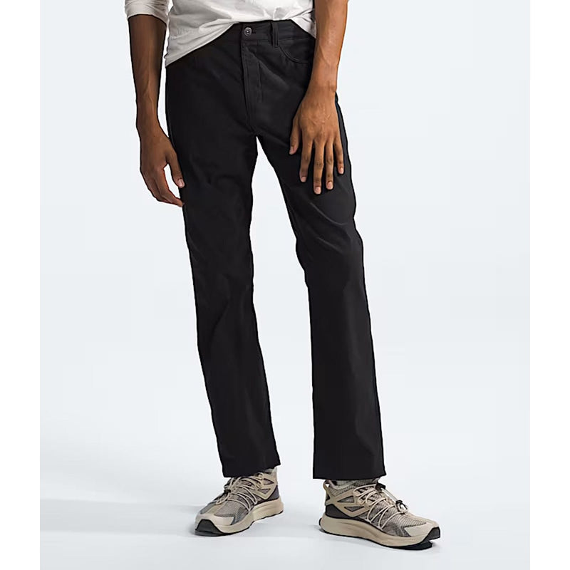 Load image into Gallery viewer, Person wearing black pants and beige sneakers on a white background
