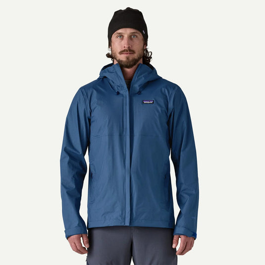 Man wearing a blue rain jacket with a visible brand logo on a white background
