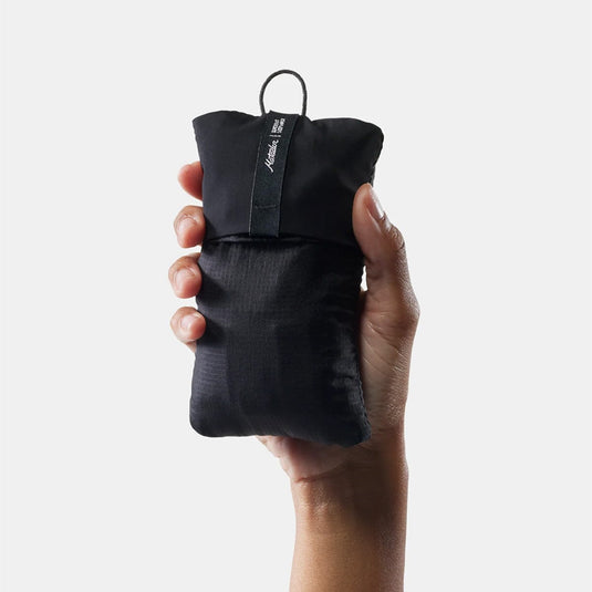 Hand holding a black对手包 with a visible brand logo on a white background