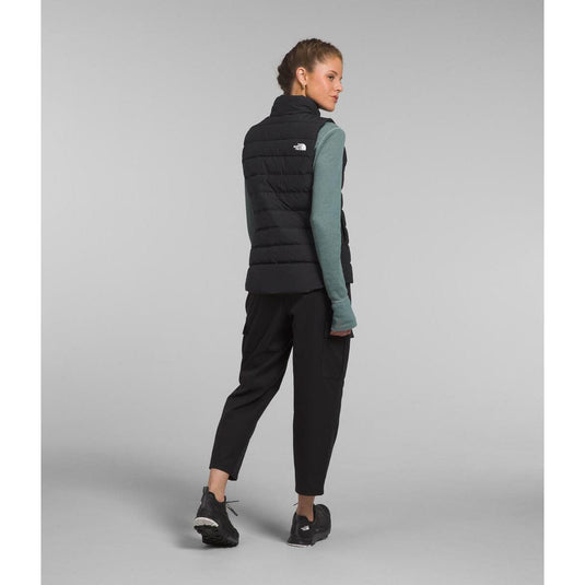 Woman wearing a black puffer vest with a gray background