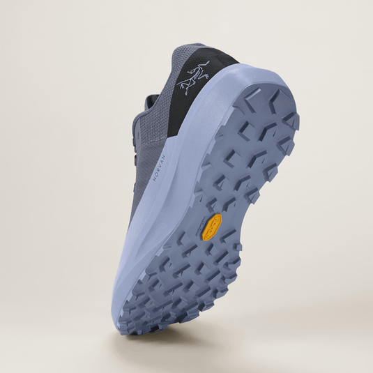 Blue hiking shoe with a textured sole on a beige background