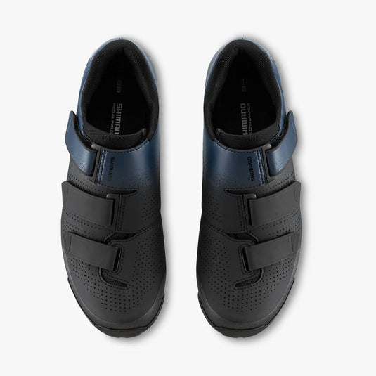 Pair of black cycling shoes with velcro straps on a white background