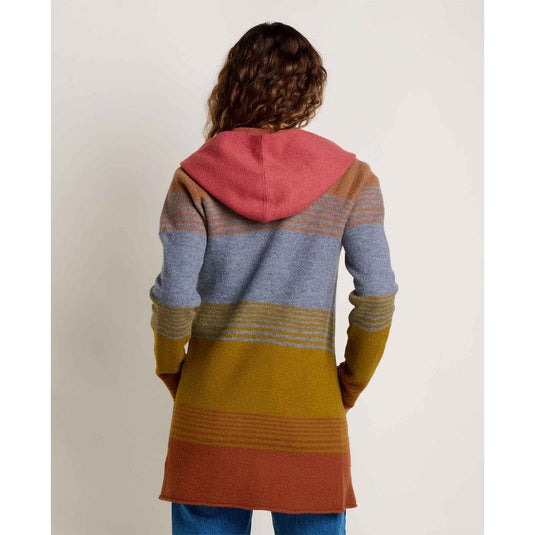 Person wearing a colorful striped hoodie with a plain background