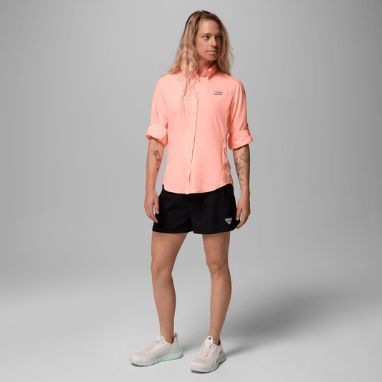 Person wearing a pink shirt and black shorts on a gray background