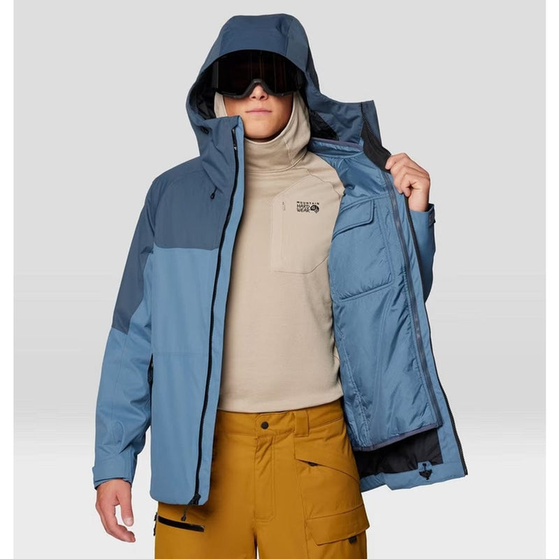 Load image into Gallery viewer, Person wearing a blue jacket with a hood, beige turtleneck, and mustard pants on a light gray background
