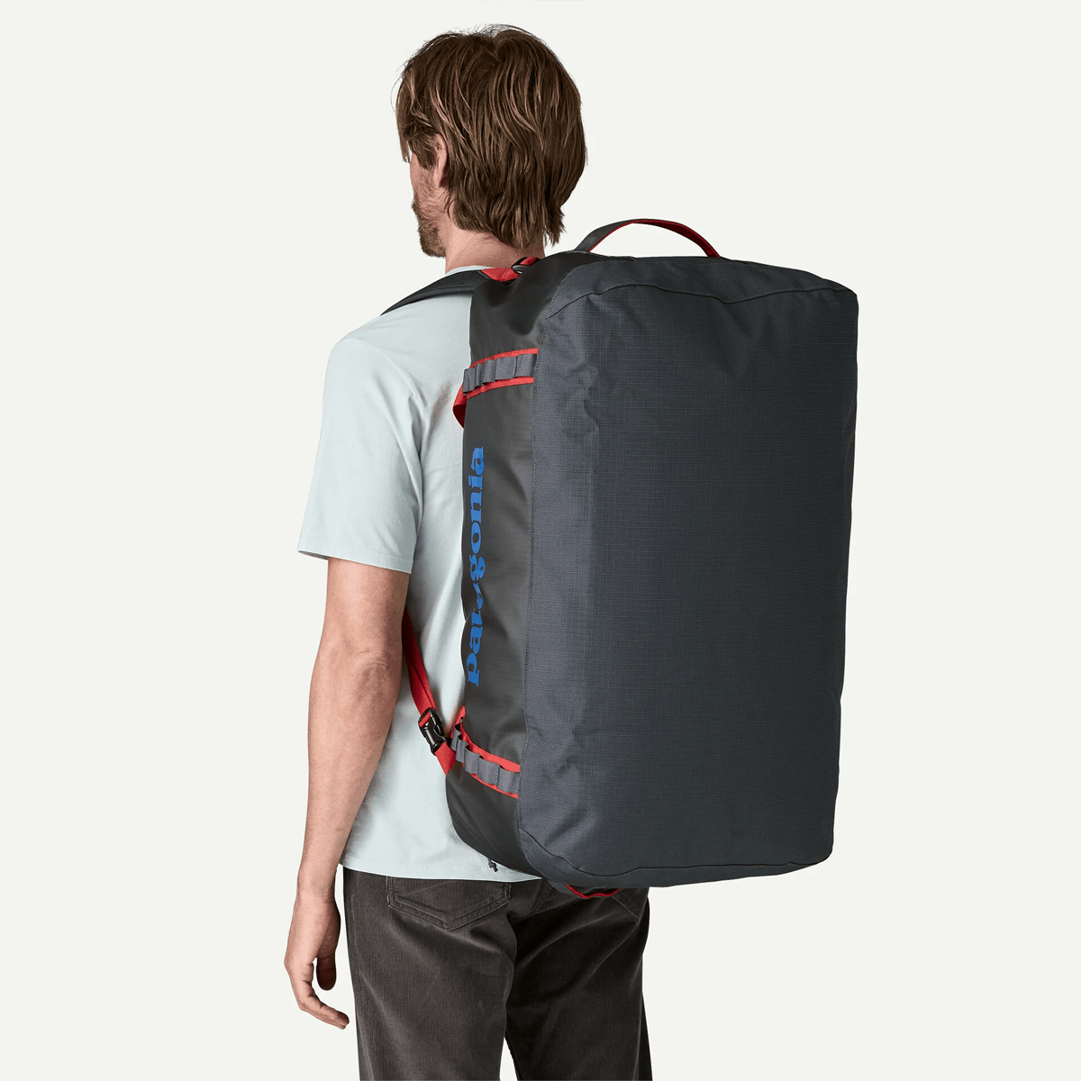 Person wearing a large black backpack on a white background