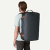 Person wearing a large black backpack on a white background