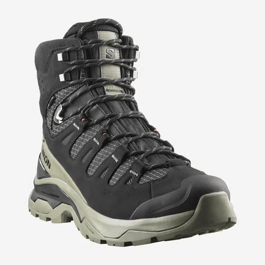 Black hiking boot with beige sole on a white background