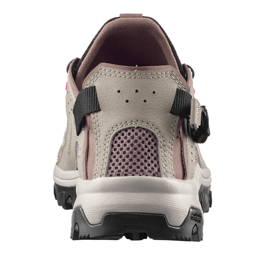 Back view of a beige hiking shoe with black straps on a white background