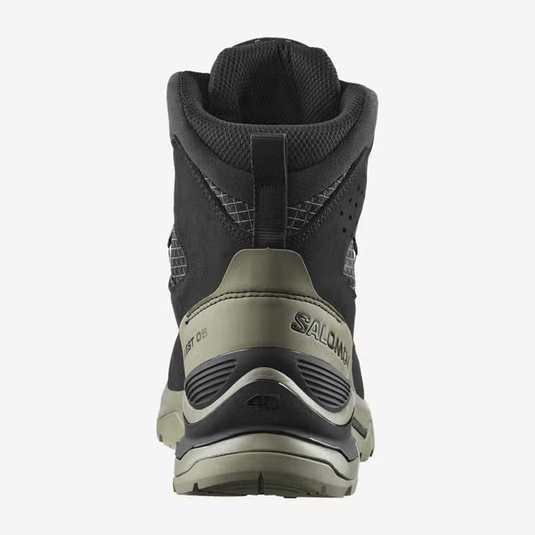 Black hiking boot with beige sole on a white background